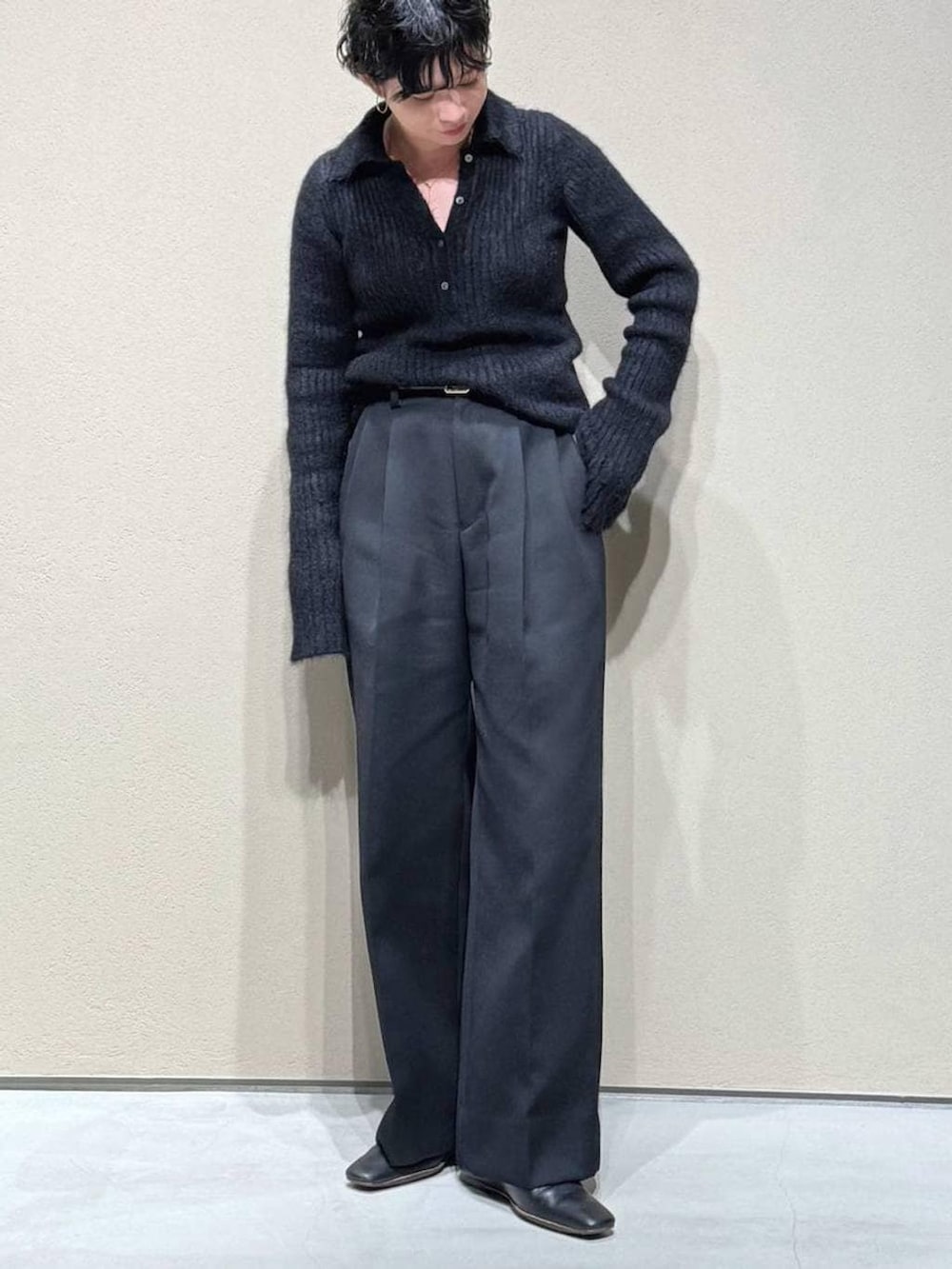 グレー系のチェスターコート、ブラック系のスラックス、ブラック系のニット/セーターを着用したレディースの冬コーディネートの6枚目の写真