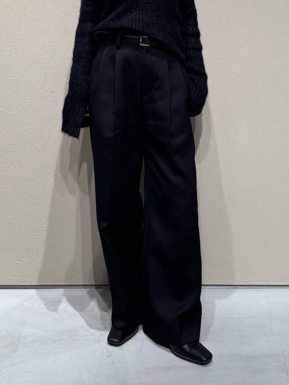 グレー系のチェスターコート、ブラック系のスラックス、ブラック系のニット/セーターを着用したレディースの冬コーディネートの8枚目の写真