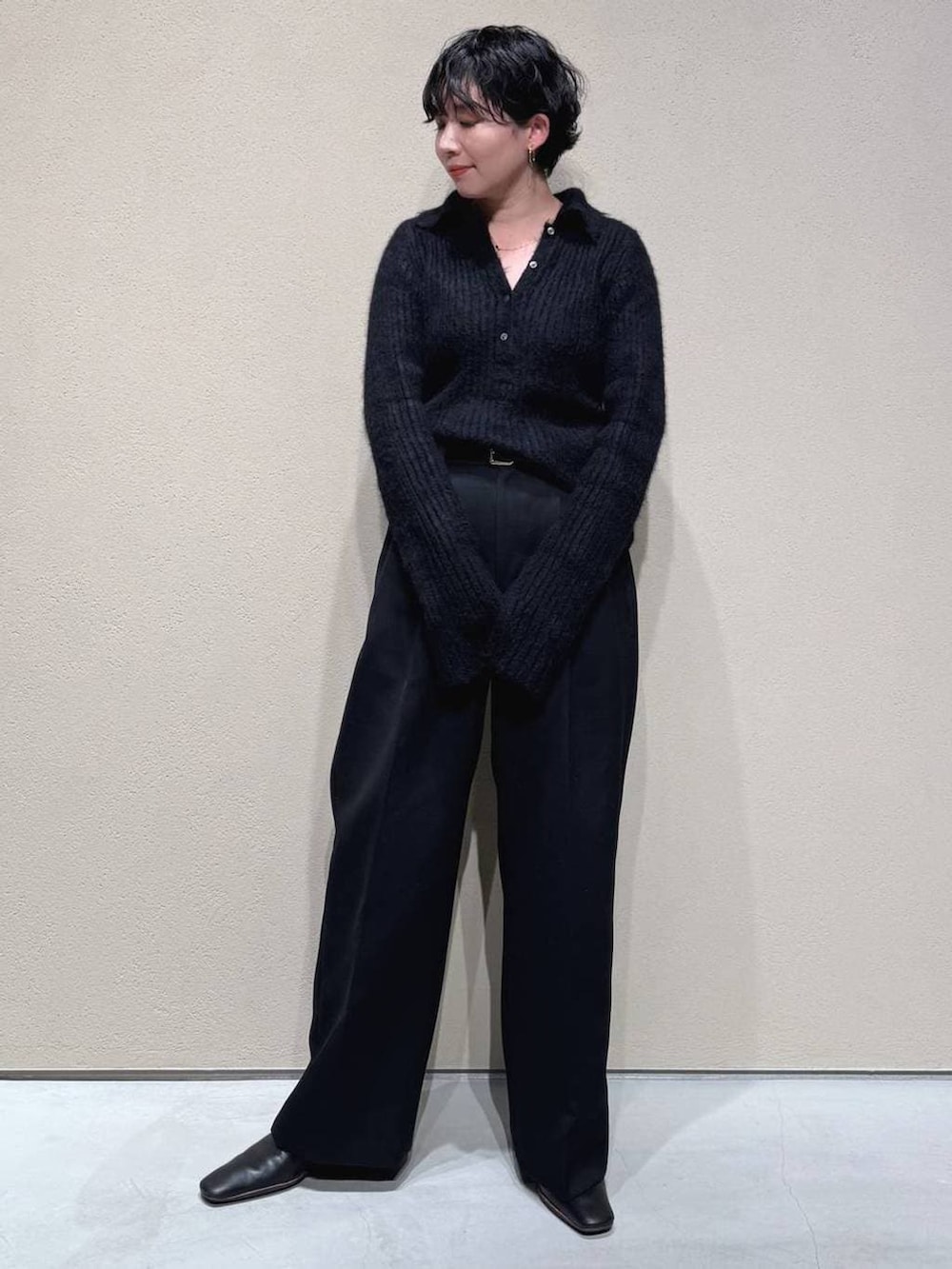 グレー系のチェスターコート、ブラック系のスラックス、ブラック系のニット/セーターを着用したレディースの冬コーディネートの5枚目の写真