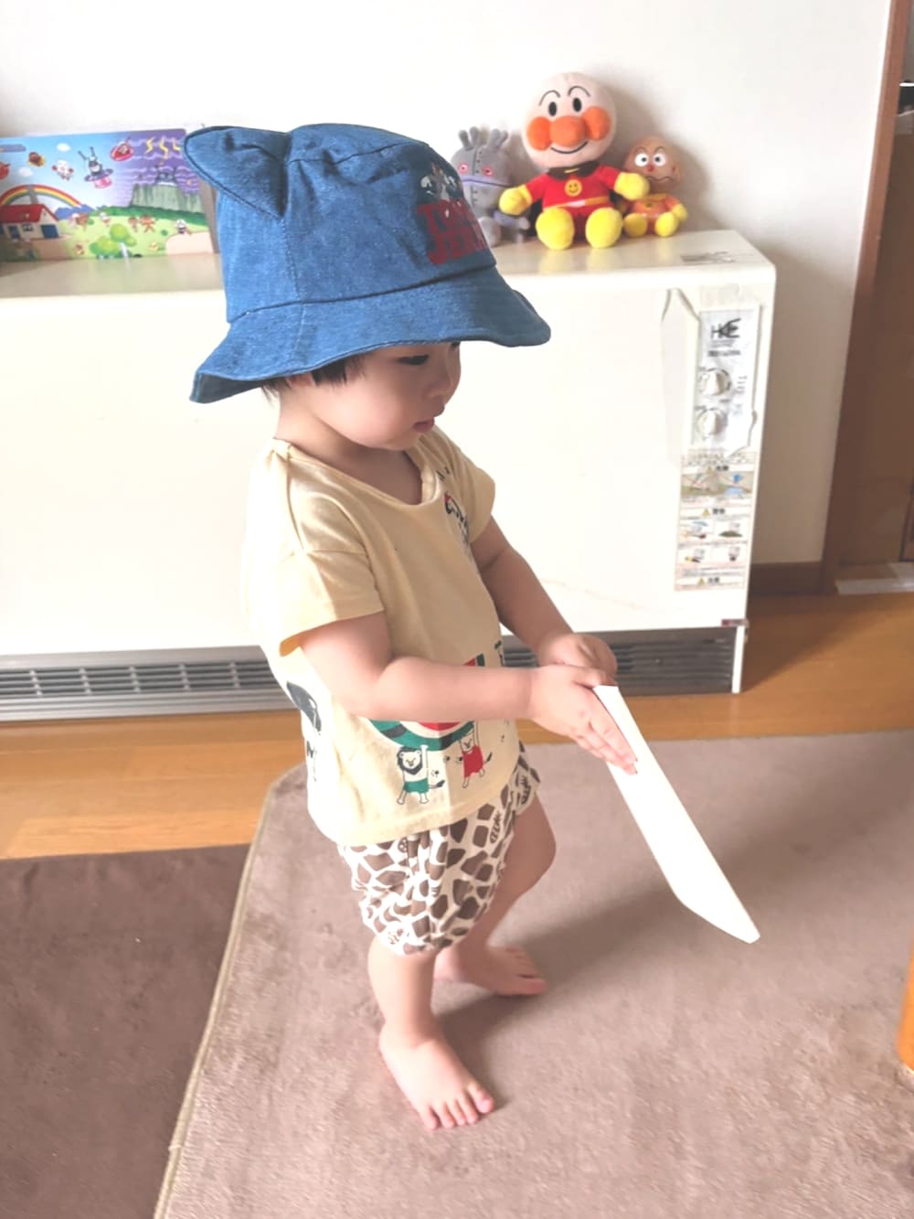 ベージュ系のTシャツ/カットソー、ベージュ系のパンツ、ブルー系のハットを着用したキッズの夏コーディネートの2枚目の写真