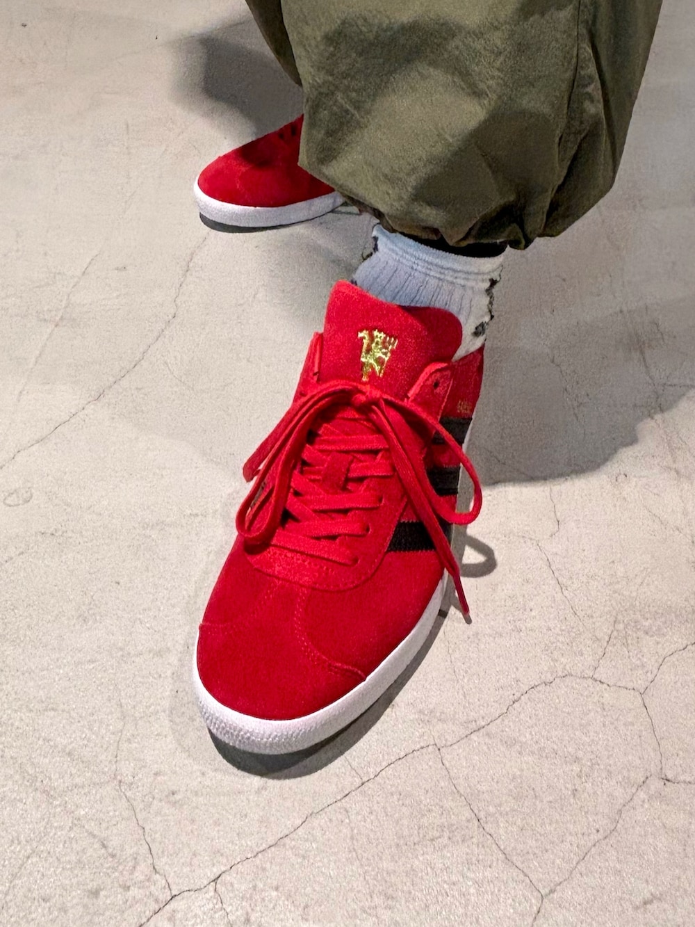 ブラック系のTシャツ/カットソー、グリーン系のカーゴパンツ、レッド系のシューズを着用したメンズの秋コーディネートの3枚目の写真