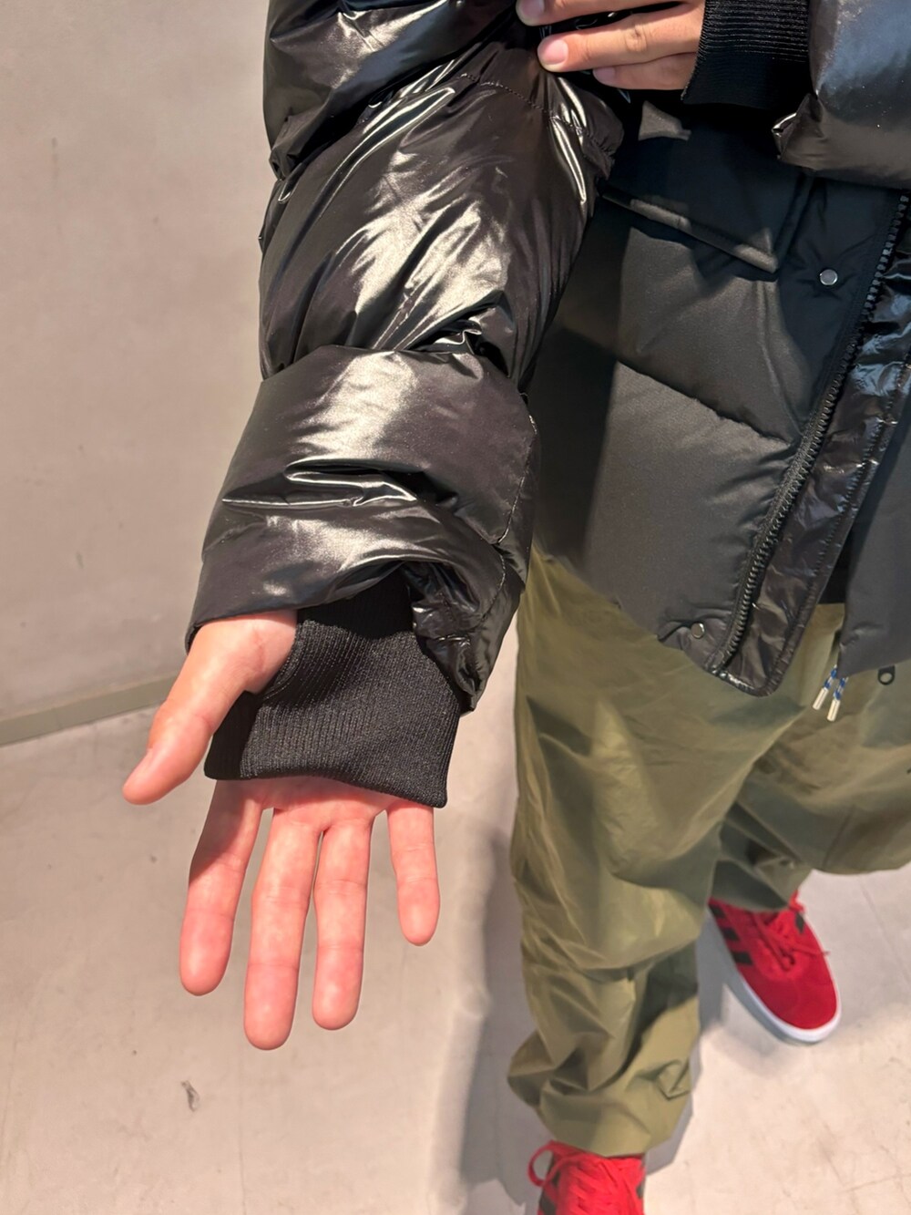 ブラック系のTシャツ/カットソー、グリーン系のカーゴパンツ、レッド系のシューズを着用したメンズの秋コーディネートの5枚目の写真