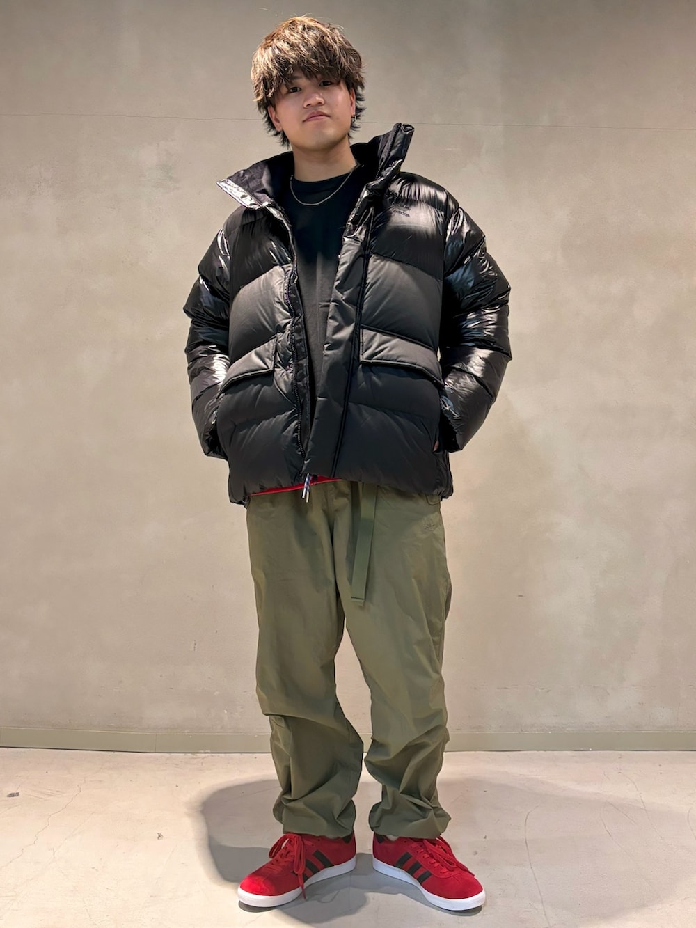 ブラック系のTシャツ/カットソー、グリーン系のカーゴパンツ、レッド系のシューズを着用したメンズの秋コーディネートの2枚目の写真