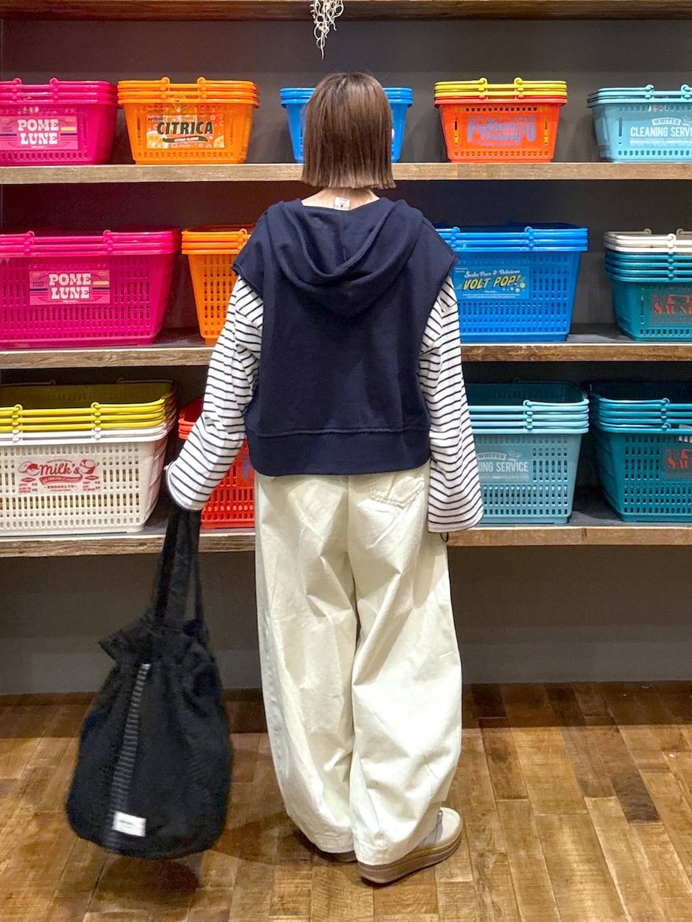 ベージュ系のスニーカー、ホワイト系のTシャツ/カットソー、ブルー系のベストを着用したレディースの春コーディネートの3枚目の写真