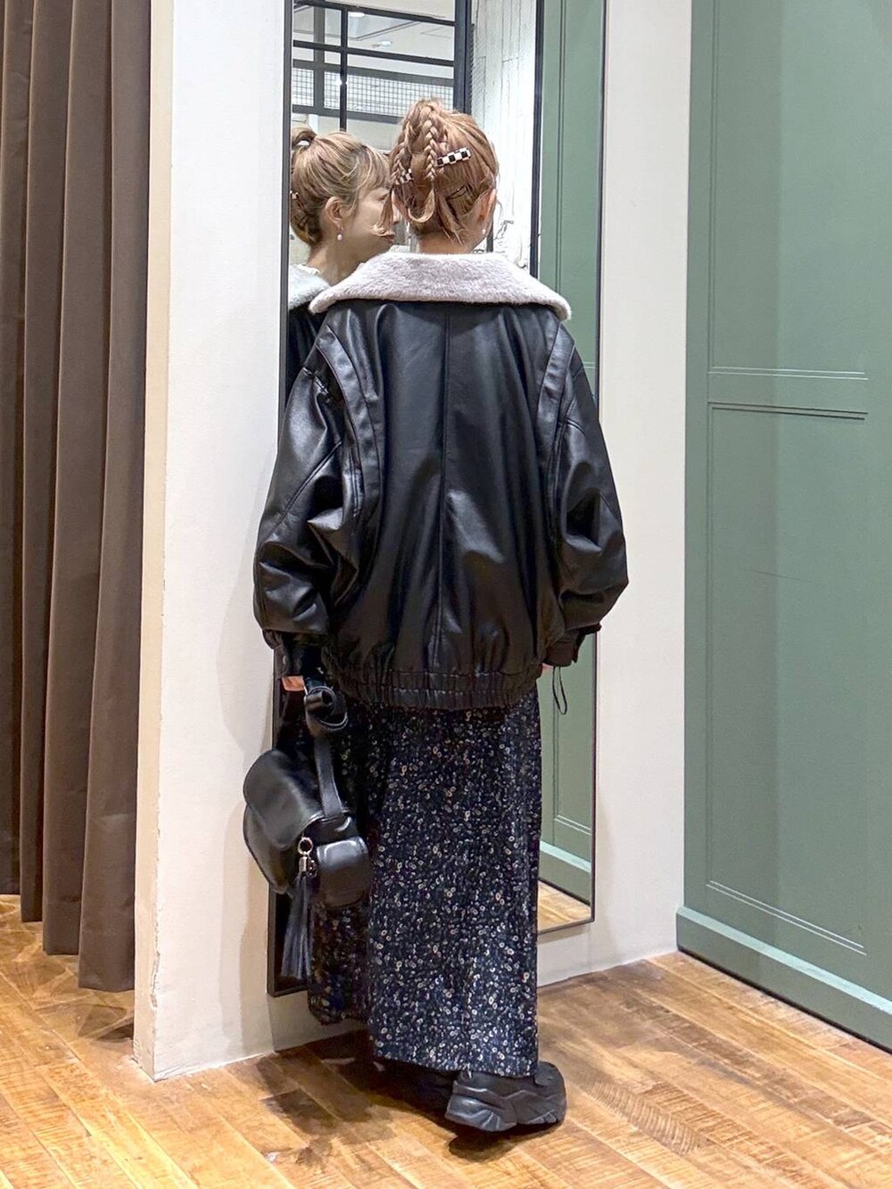 ブラック系のブルゾン、ブラック系のショルダーバッグ、ベージュ系のニット/セーターを着用したレディースの秋コーディネートの3枚目の写真