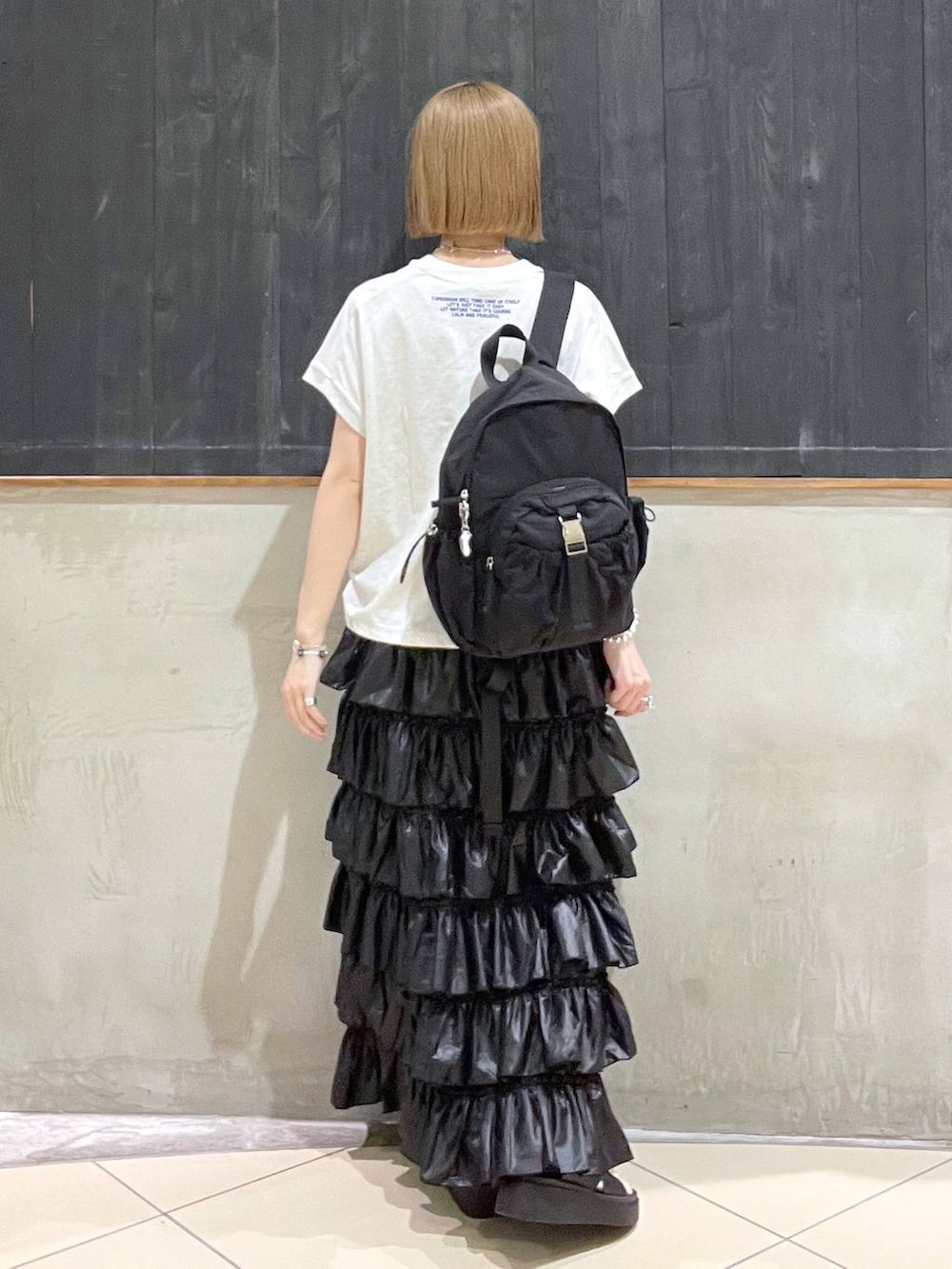 ブラック系のサンダル、ベージュ系のTシャツ/カットソー、ブラック系のバックパック/リュックを着用したレディースの夏コーディネートの3枚目の写真