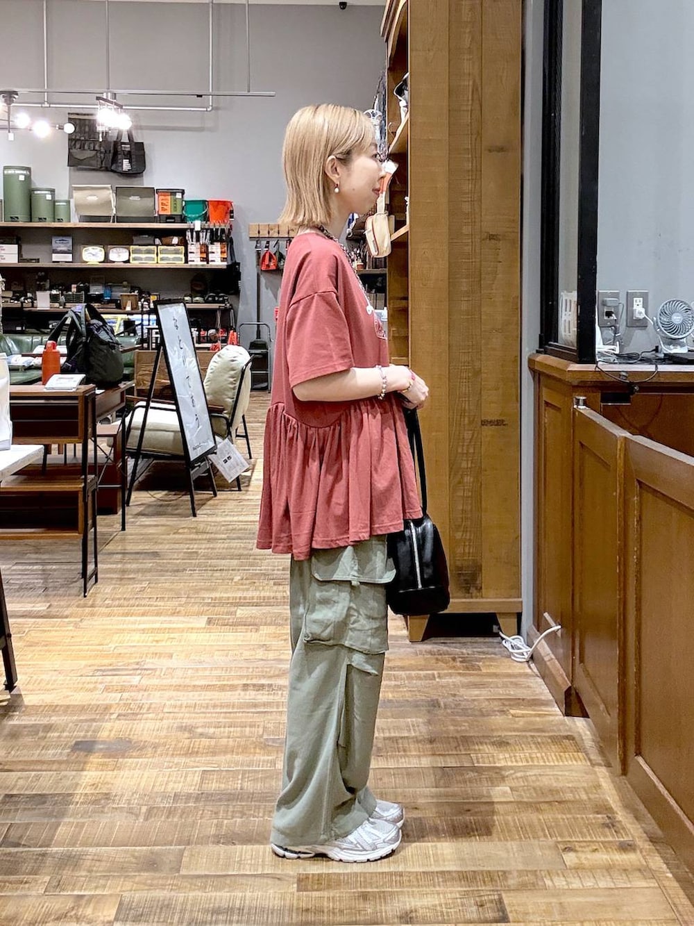 グリーン系のカーゴパンツ、レッド系のTシャツ/カットソーを着用したレディースの夏コーディネートの2枚目の写真