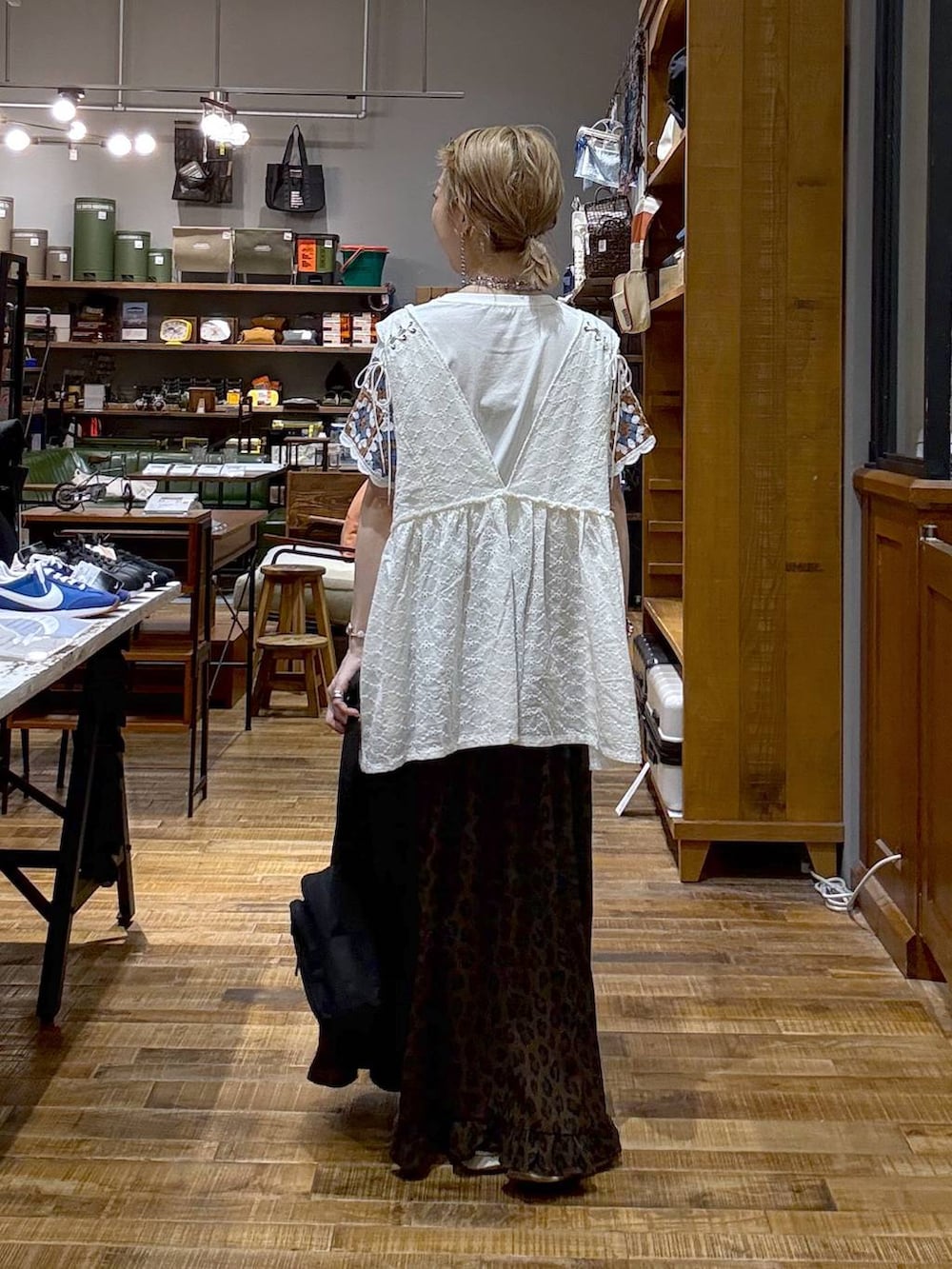 ホワイト系のベスト、シルバー系のスニーカー、ブラウン系のスカートを着用したレディースの夏コーディネートの3枚目の写真