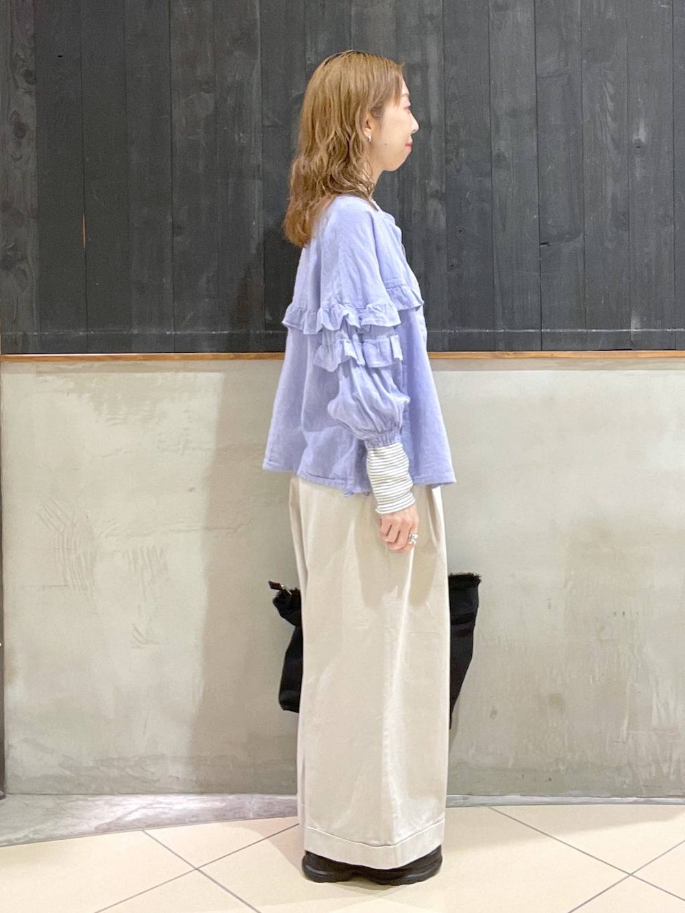 ブラック系のローファー、ベージュ系のその他パンツ、ブラック系のショルダーバッグを着用したレディースの春コーディネートの2枚目の写真