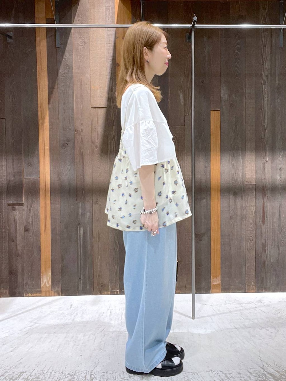 ブラック系のサンダル、ベージュ系のキャミソール、ブラック系のショルダーバッグを着用したレディースの春コーディネートの2枚目の写真