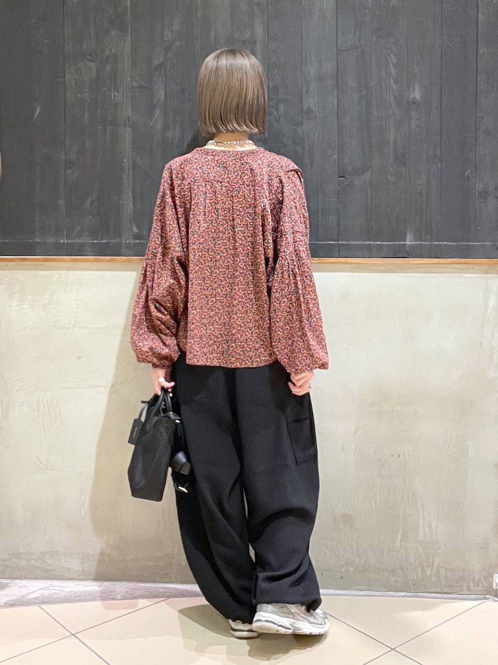 レッド系のシャツ/ブラウス、ブラック系のその他パンツ、ブラック系のショルダーバッグを着用したレディースの秋コーディネートの4枚目の写真