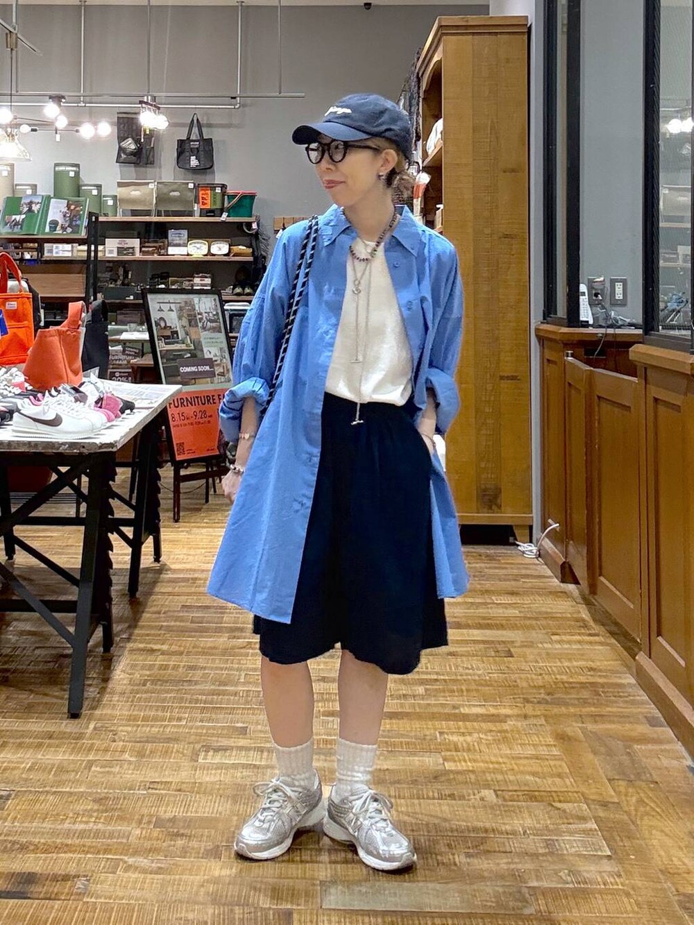 ホワイト系のTシャツ/カットソー、ブルー系のシャツ/ブラウス、ホワイト系のバックパック/リュックを着用したレディースの夏コーディネートの2枚目の写真