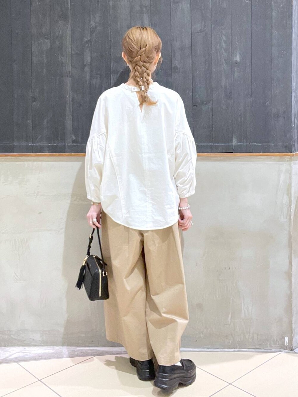 ブラック系のローファー、ベージュ系のその他パンツ、ブラック系のショルダーバッグを着用したレディースの春コーディネートの3枚目の写真