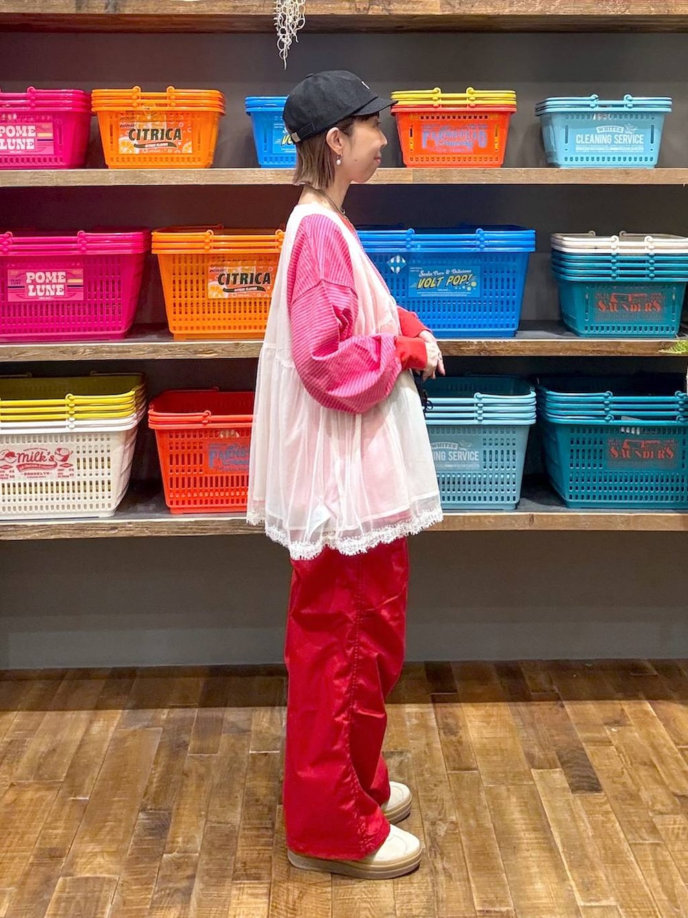 ベージュ系のスニーカー、ホワイト系のベスト、ブラック系のボディバッグ/ウエストポーチを着用したレディースの春コーディネートの2枚目の写真