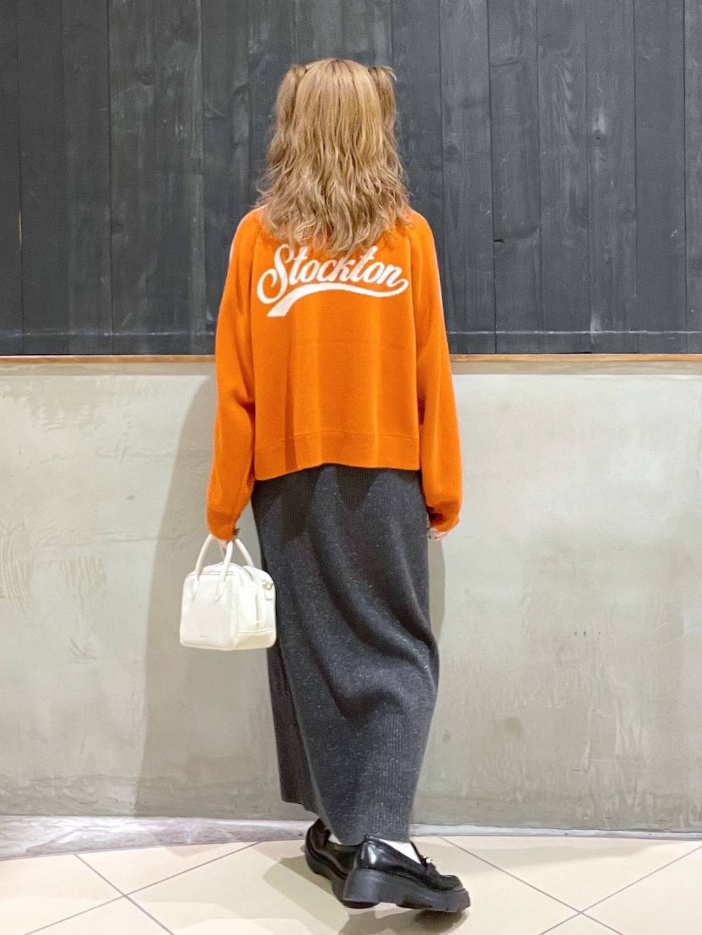 ブラック系のローファー、ベージュ系のショルダーバッグ、ホワイト系のTシャツ/カットソーを着用したレディースの冬コーディネートの3枚目の写真