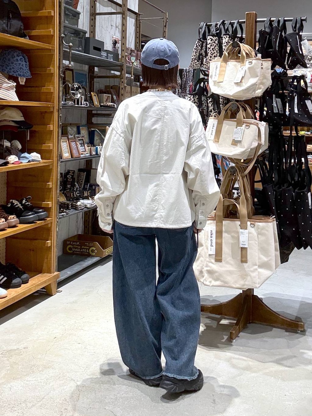 ベージュ系のカバーオール、ブルー系のデニムパンツ、ブラック系のボディバッグ/ウエストポーチを着用したレディースの春コーディネートの3枚目の写真