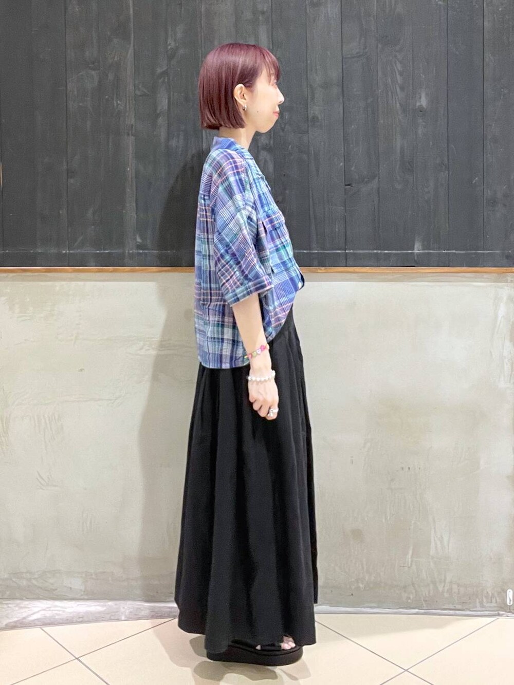 ブラック系のショルダーバッグ、ブラック系のサンダル、ブラック系のスカートを着用したレディースの夏コーディネートの2枚目の写真