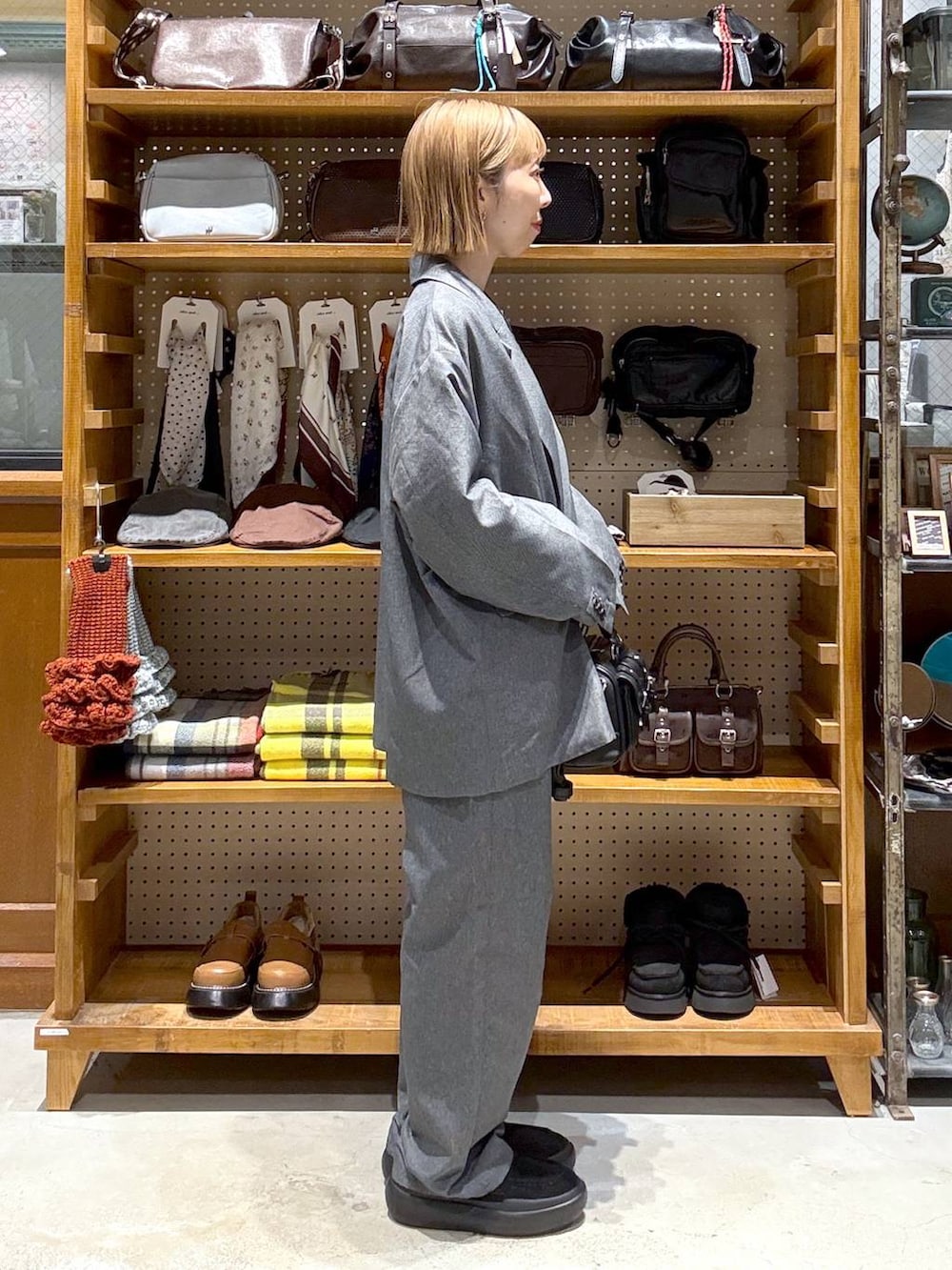 ブラック系のボストンバッグ、ブラック系のシャツ/ブラウス、ブラック系のローファーを着用したレディースの春コーディネートの2枚目の写真