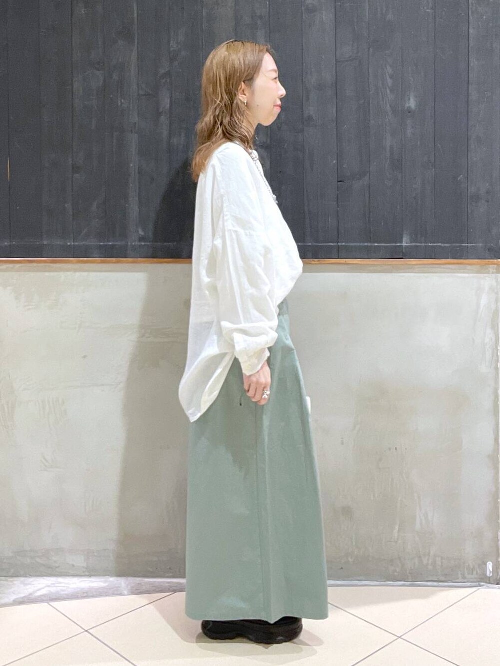 ブラック系のローファー、グリーン系のその他パンツ、ホワイト系のTシャツ/カットソーを着用したレディースの春コーディネートの2枚目の写真