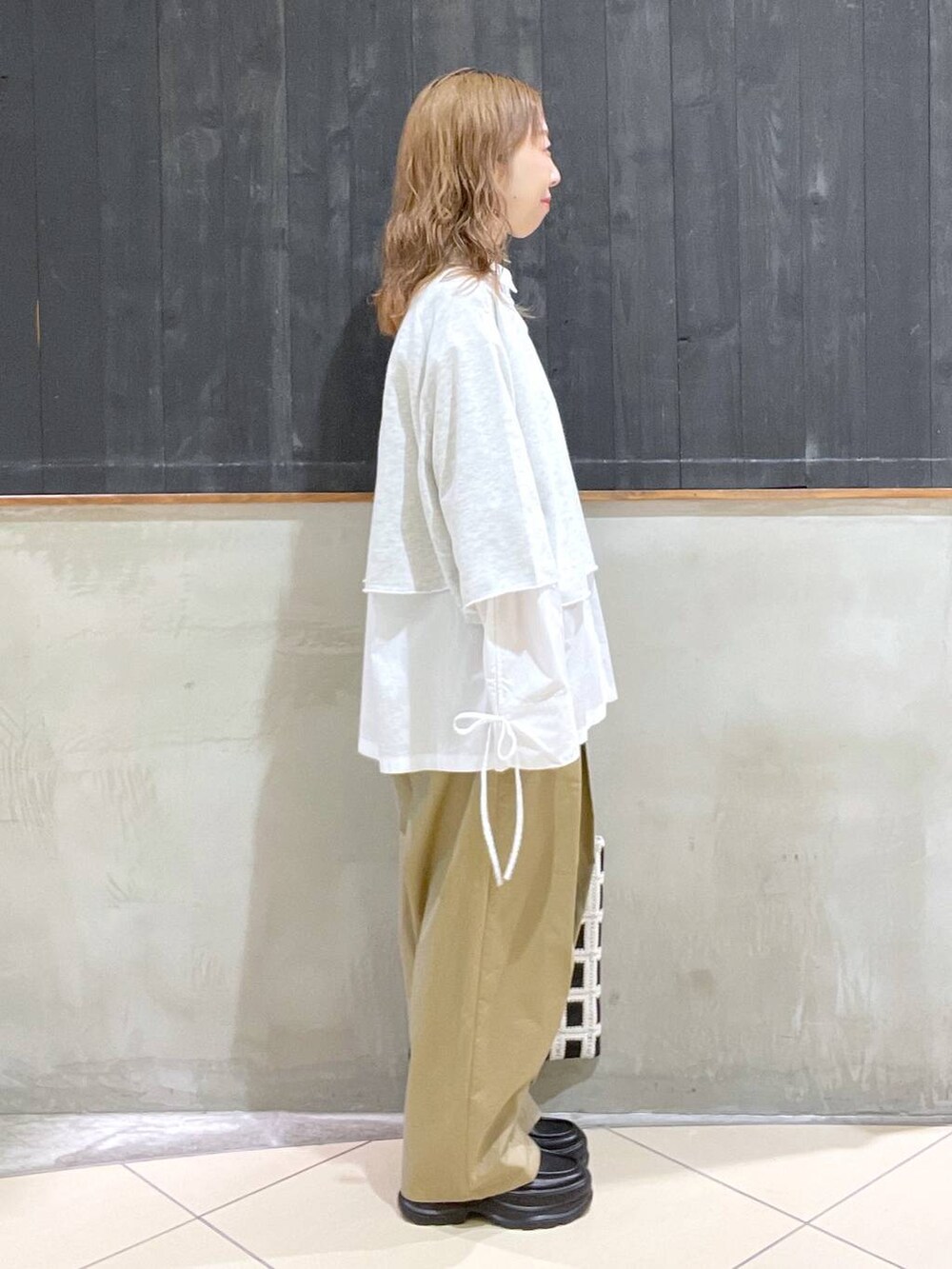 ブラック系のローファー、ベージュ系のチノパンツ、ベージュ系のTシャツ/カットソーを着用したレディースの春コーディネートの2枚目の写真