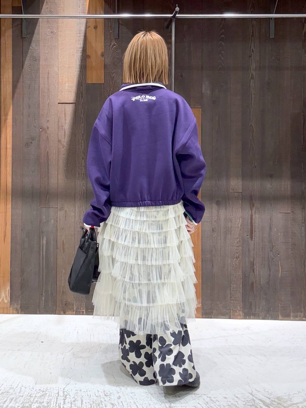 ホワイト系のTシャツ/カットソー、ホワイト系のスカート、ブラック系のショルダーバッグを着用したレディースの冬コーディネートの3枚目の写真