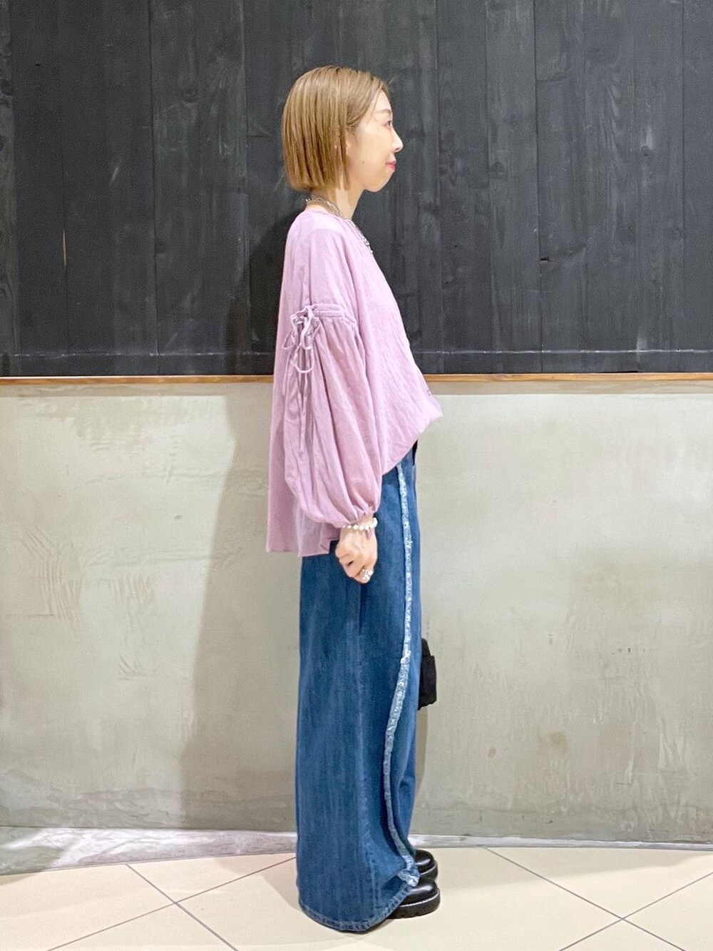 ブラック系のその他シューズ、ブルー系のデニムパンツ、ブラック系のショルダーバッグを着用したレディースの夏コーディネートの3枚目の写真