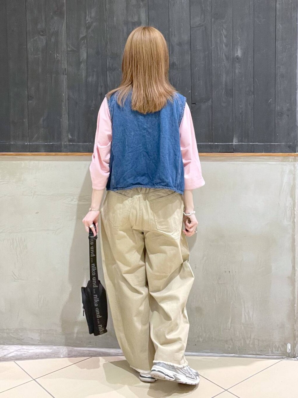 ピンク系のTシャツ/カットソー、ブラック系のショルダーバッグ、ブルー系のベストを着用したレディースの春コーディネートの3枚目の写真