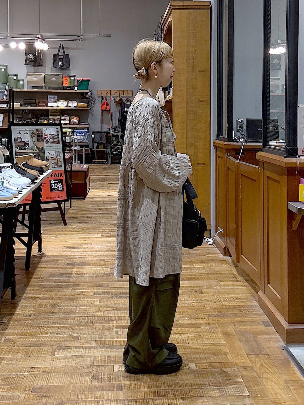 グリーン系のカーゴパンツ、グレー系のワンピース、ブラック系のショルダーバッグを着用したレディースの秋コーディネートの2枚目の写真