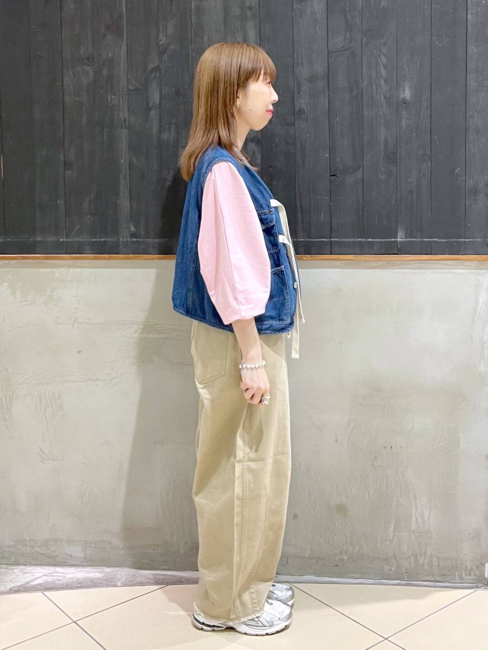 ピンク系のTシャツ/カットソー、ブラック系のショルダーバッグ、ブルー系のベストを着用したレディースの春コーディネートの2枚目の写真