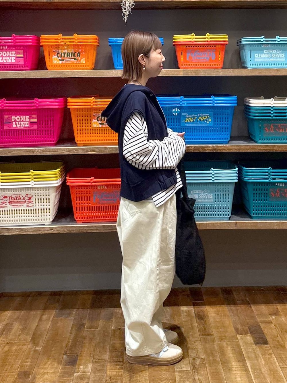 ベージュ系のスニーカー、ホワイト系のTシャツ/カットソー、ブルー系のベストを着用したレディースの春コーディネートの2枚目の写真