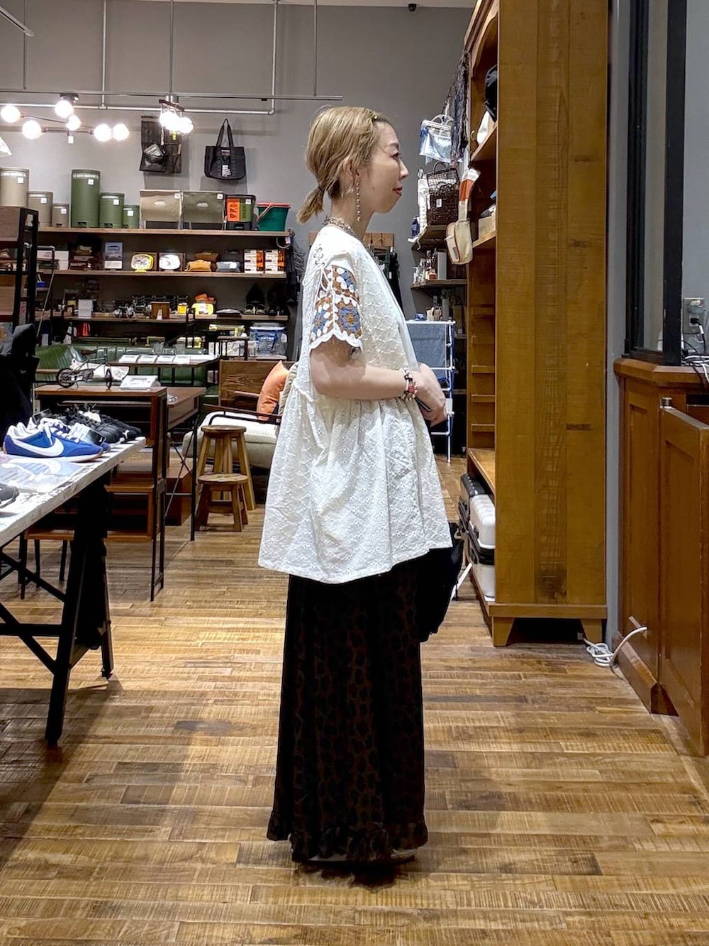 ホワイト系のベスト、シルバー系のスニーカー、ブラウン系のスカートを着用したレディースの夏コーディネートの2枚目の写真