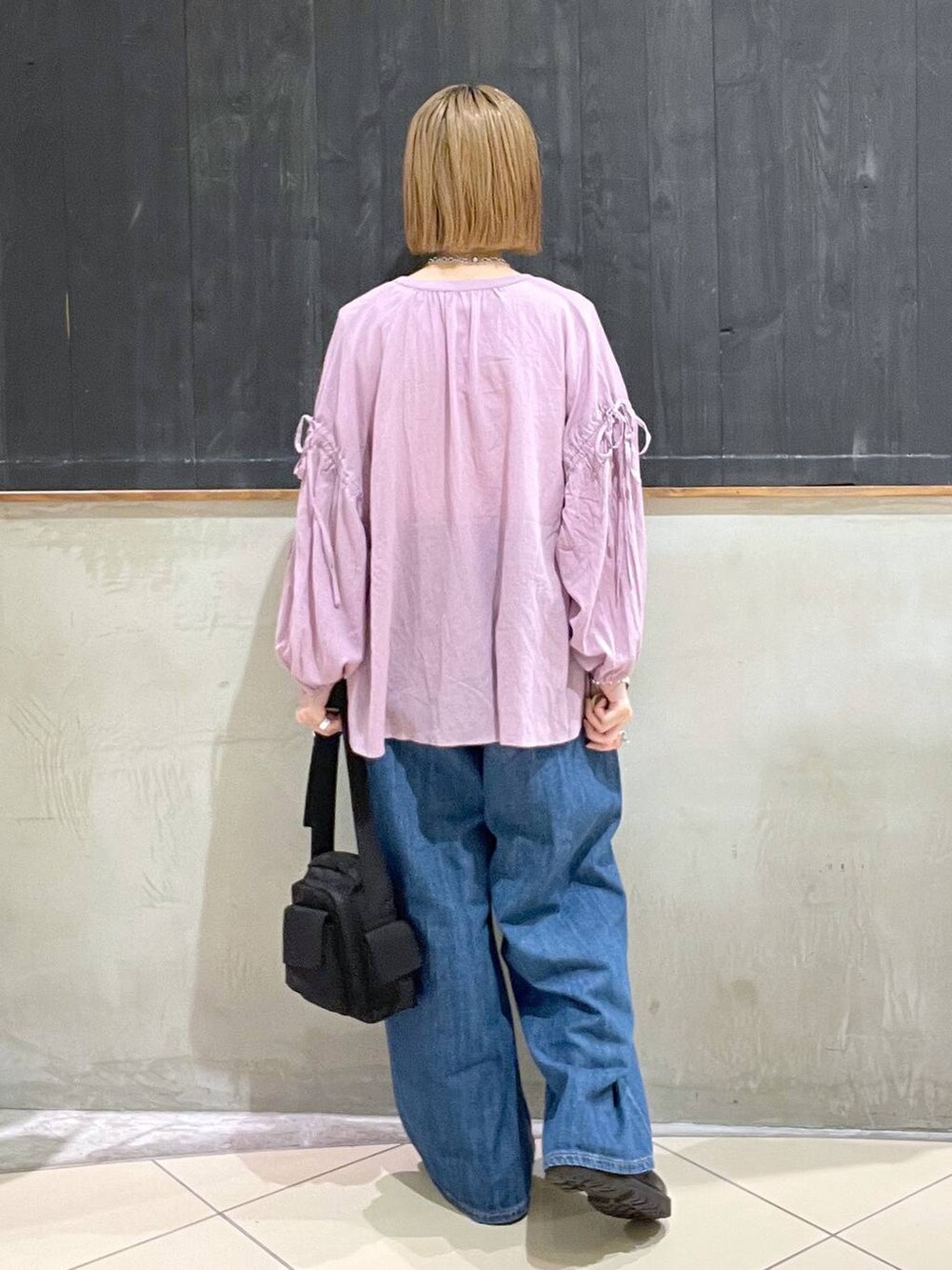 ブラック系のその他シューズ、ブルー系のデニムパンツ、ブラック系のショルダーバッグを着用したレディースの夏コーディネートの4枚目の写真