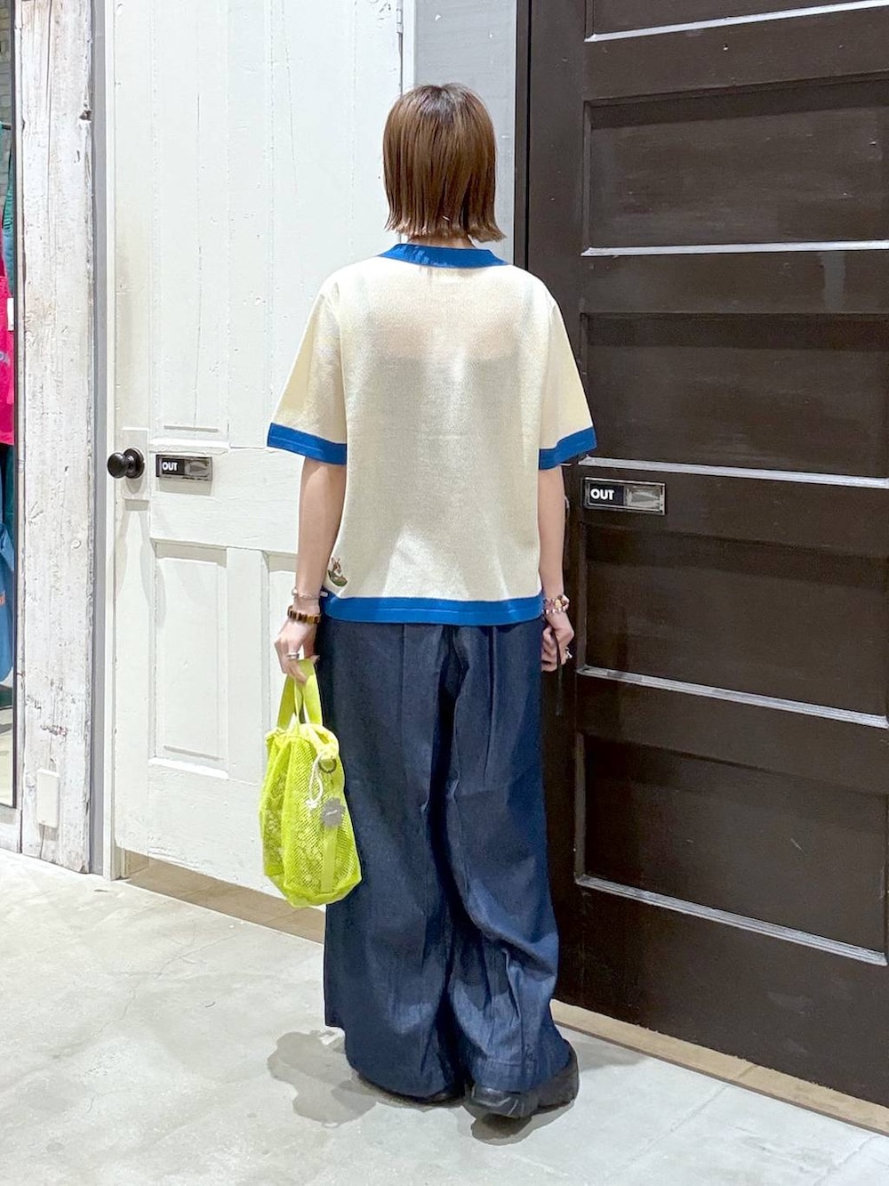 ベージュ系のニット/セーター、イエロー系のショルダーバッグを着用したレディースの春コーディネートの3枚目の写真