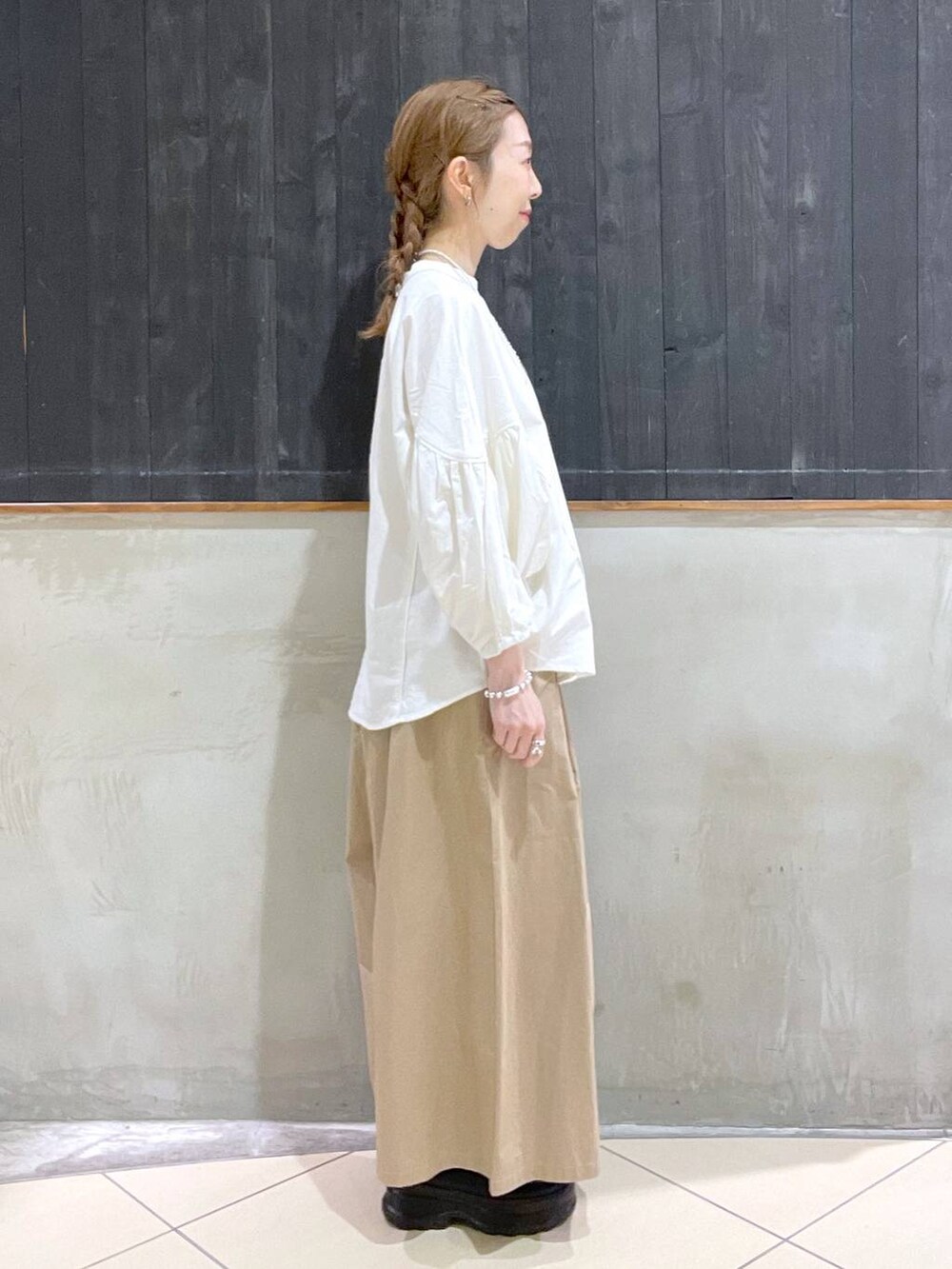 ブラック系のローファー、ベージュ系のその他パンツ、ブラック系のショルダーバッグを着用したレディースの春コーディネートの2枚目の写真