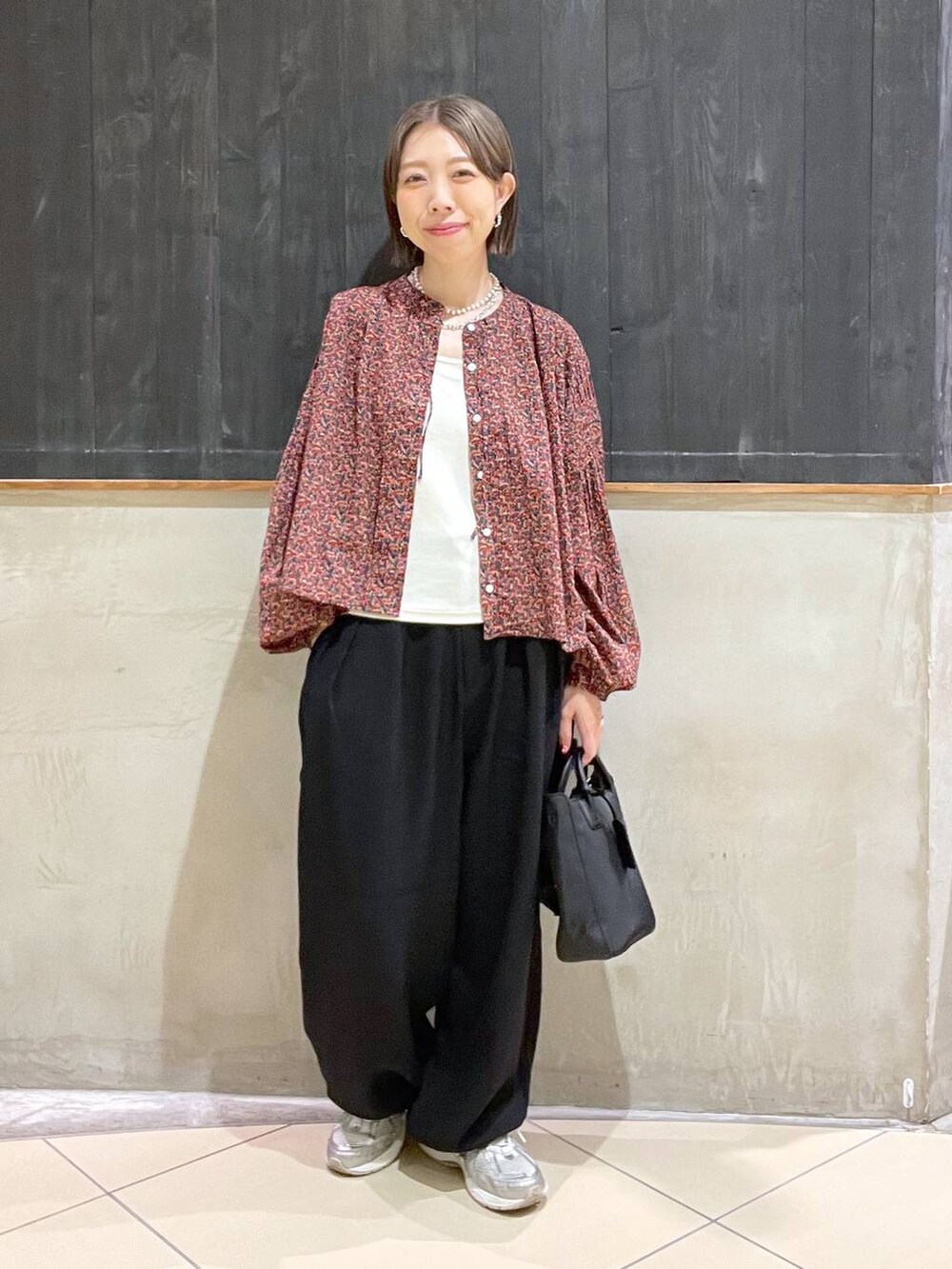 レッド系のシャツ/ブラウス、ブラック系のその他パンツ、ブラック系のショルダーバッグを着用したレディースの秋コーディネートの2枚目の写真