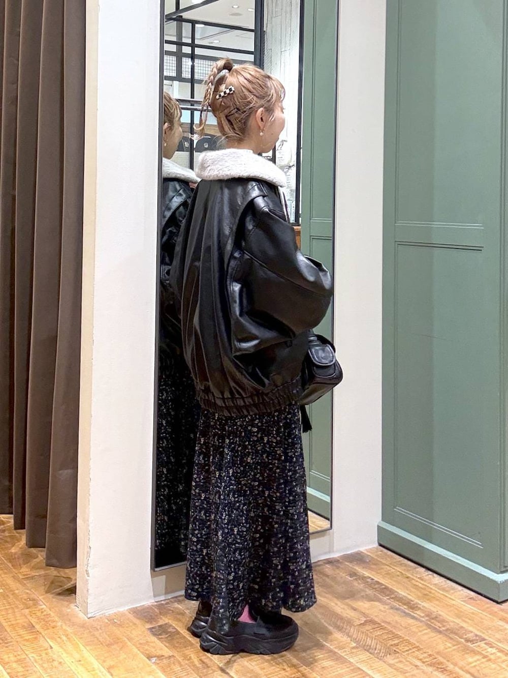 ブラック系のブルゾン、ブラック系のショルダーバッグ、ベージュ系のニット/セーターを着用したレディースの秋コーディネートの2枚目の写真