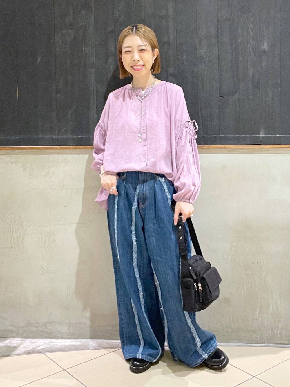 ブラック系のその他シューズ、ブルー系のデニムパンツ、ブラック系のショルダーバッグを着用したレディースの夏コーディネートの2枚目の写真