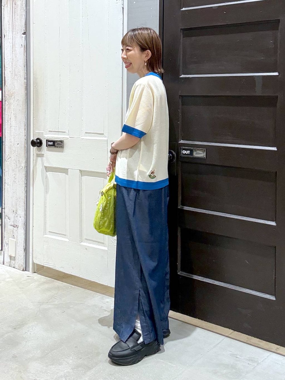 ベージュ系のニット/セーター、イエロー系のショルダーバッグを着用したレディースの春コーディネートの4枚目の写真