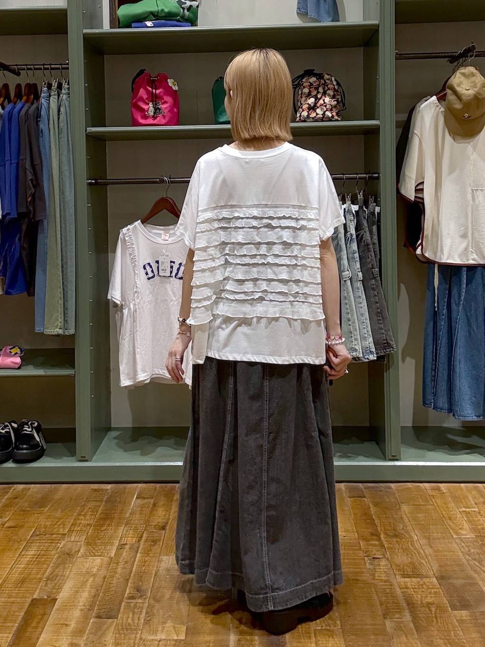 ブラック系のショルダーバッグ、グレー系のスカート、ホワイト系のTシャツ/カットソーを着用したレディースの夏コーディネートの3枚目の写真