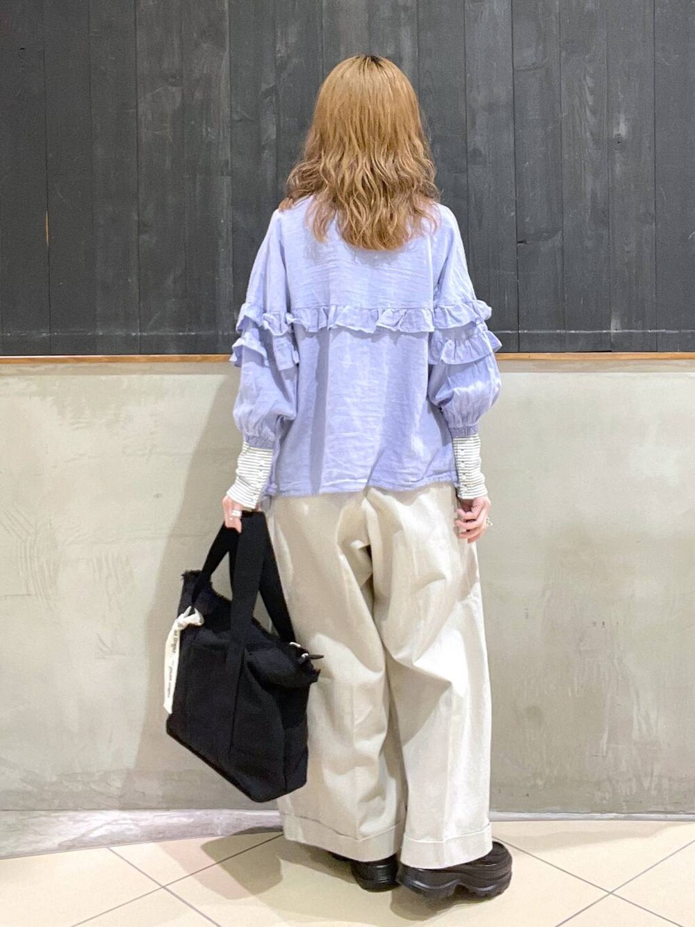 ブラック系のローファー、ベージュ系のその他パンツ、ブラック系のショルダーバッグを着用したレディースの春コーディネートの3枚目の写真