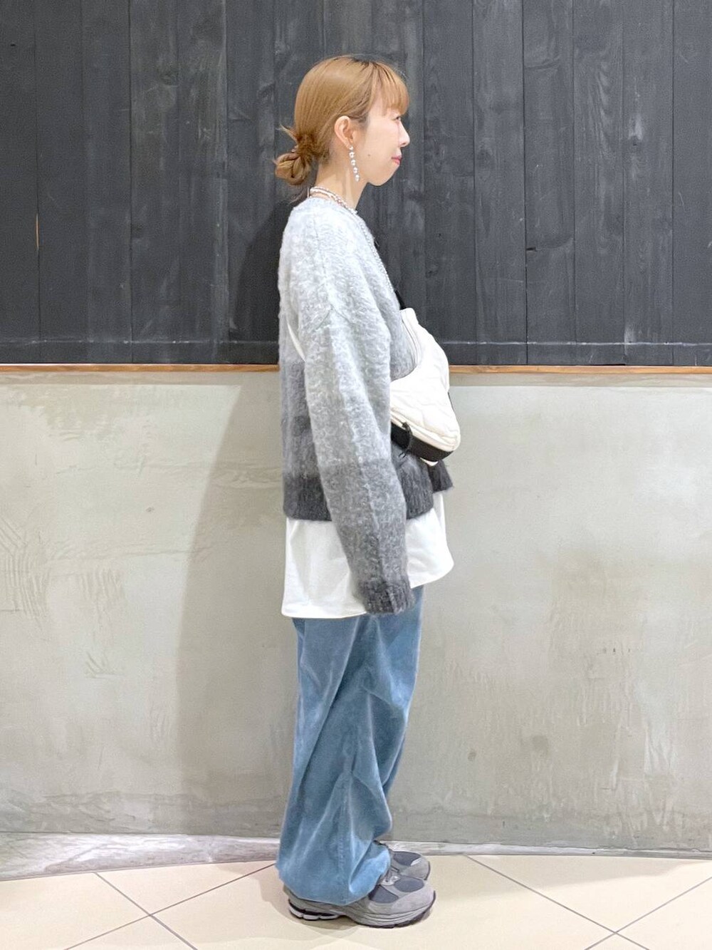 ベージュ系のショルダーバッグ、ホワイト系のTシャツ/カットソー、ブルー系のその他パンツを着用したレディースの冬コーディネートの2枚目の写真