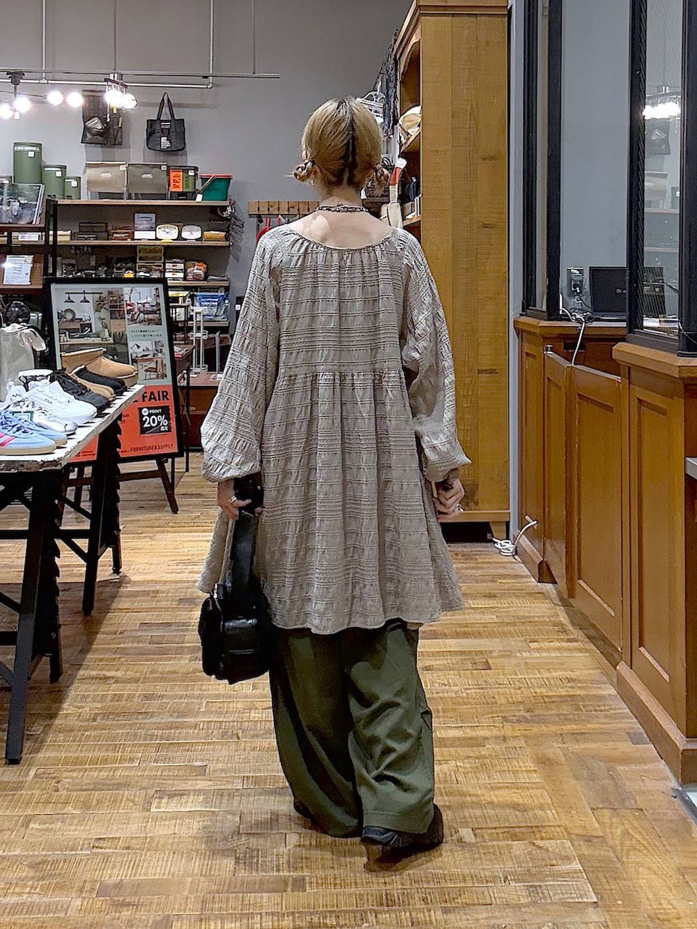 グリーン系のカーゴパンツ、グレー系のワンピース、ブラック系のショルダーバッグを着用したレディースの秋コーディネートの3枚目の写真