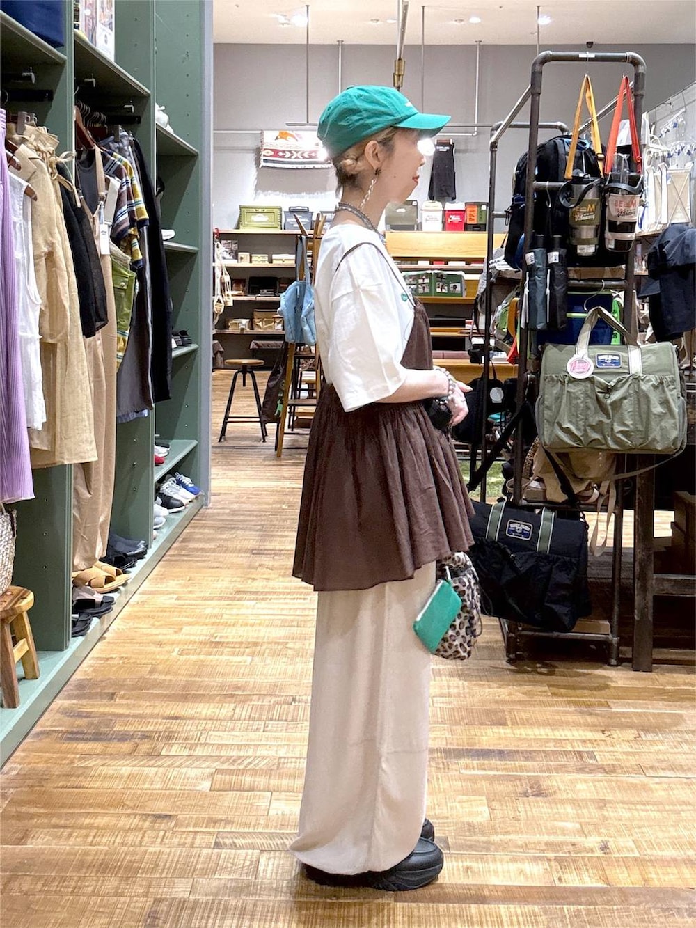 ベージュ系のその他パンツ、ブラウン系のキャミソール、その他のショルダーバッグを着用したレディースの夏コーディネートの2枚目の写真