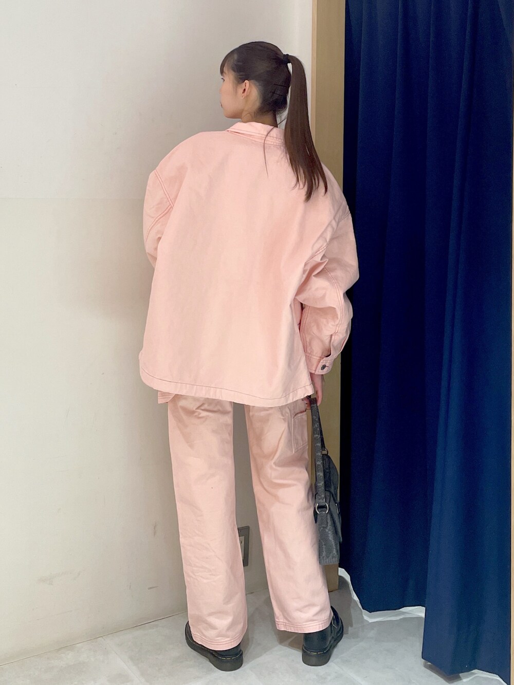 ブラック系のハンドバッグ、ピンク系のパンツ、ブラック系のTシャツ/カットソーを着用したレディースの冬コーディネートの5枚目の写真