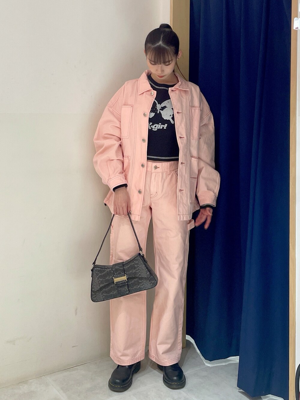 ブラック系のハンドバッグ、ピンク系のパンツ、ブラック系のTシャツ/カットソーを着用したレディースの冬コーディネートの2枚目の写真