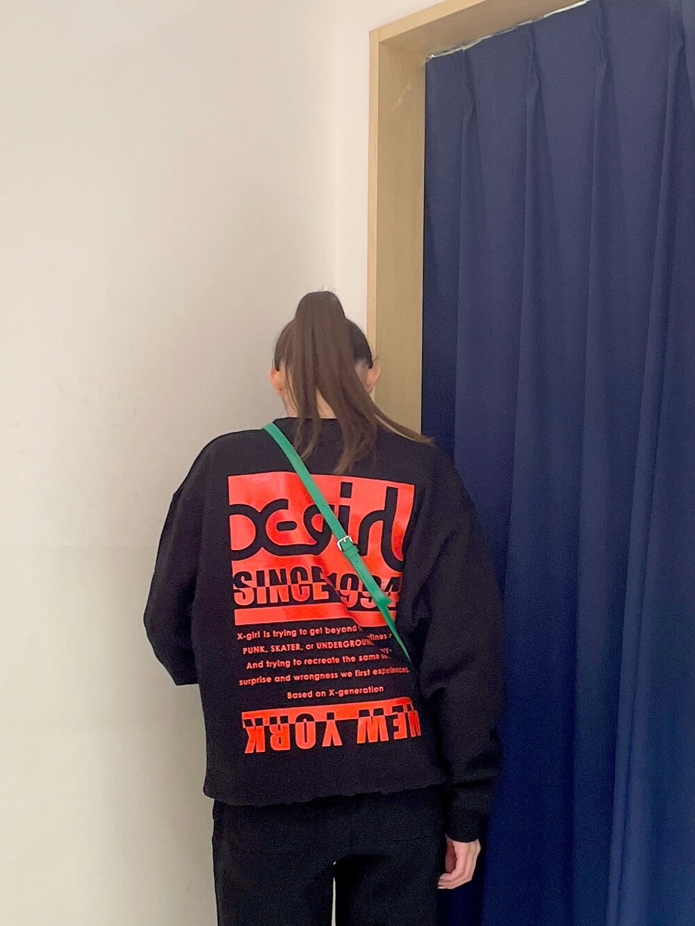 ブラック系のスウェット、グリーン系のショルダーバッグ、ブラック系のスウェットパンツを着用したレディースの冬コーディネートの4枚目の写真