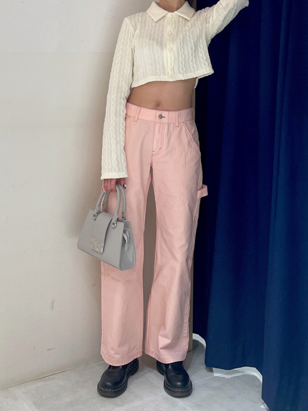 ホワイト系のポロシャツ、ピンク系のパンツ、グレー系のバッグを着用したレディースの冬コーディネートの2枚目の写真