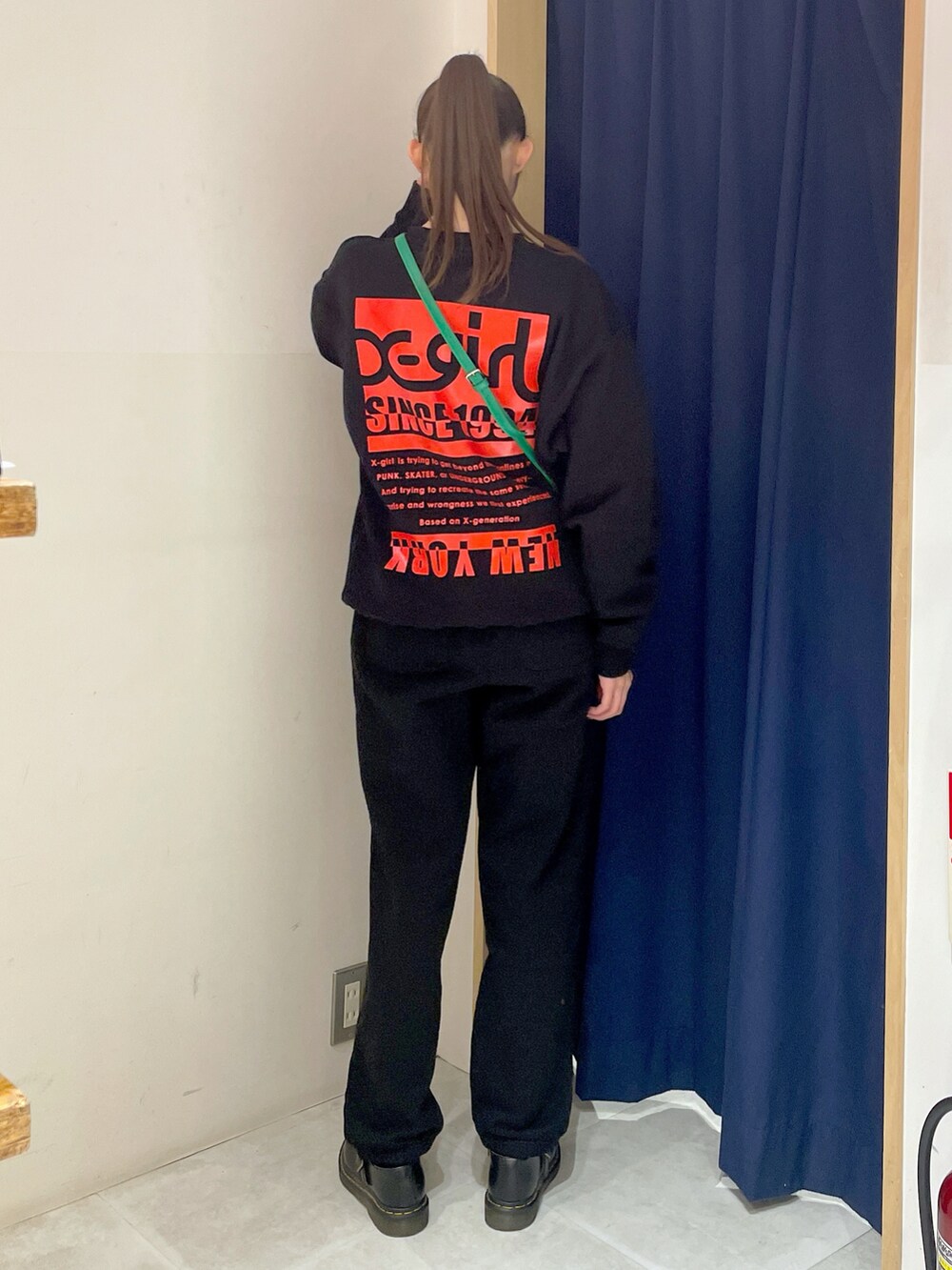 ブラック系のスウェット、グリーン系のショルダーバッグ、ブラック系のスウェットパンツを着用したレディースの冬コーディネートの5枚目の写真