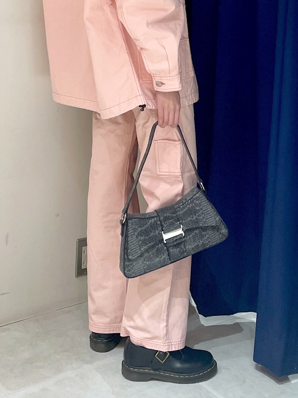 ブラック系のハンドバッグ、ピンク系のパンツ、ブラック系のTシャツ/カットソーを着用したレディースの冬コーディネートの3枚目の写真