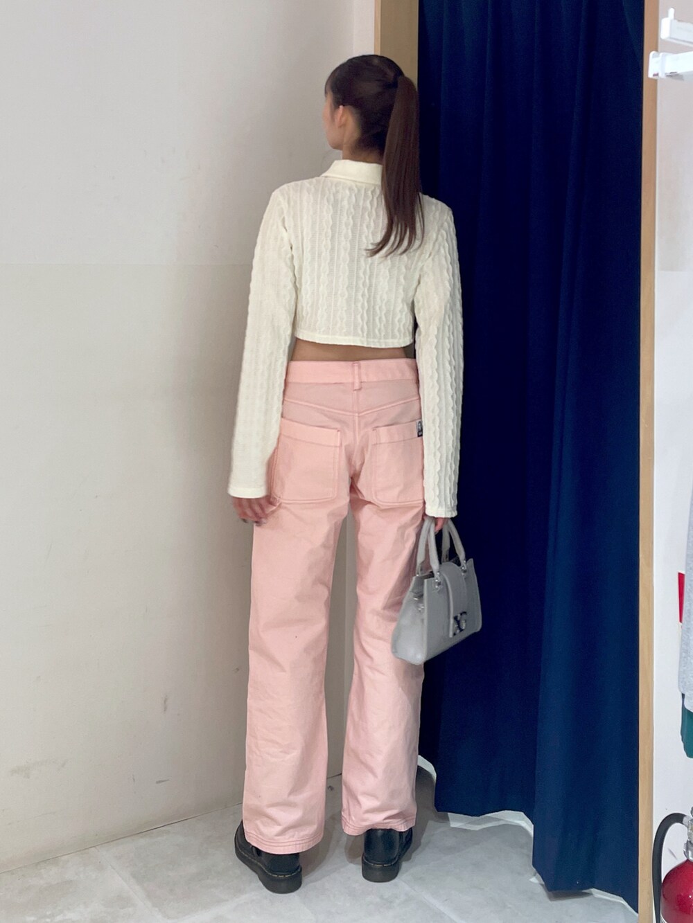 ホワイト系のポロシャツ、ピンク系のパンツ、グレー系のバッグを着用したレディースの冬コーディネートの4枚目の写真